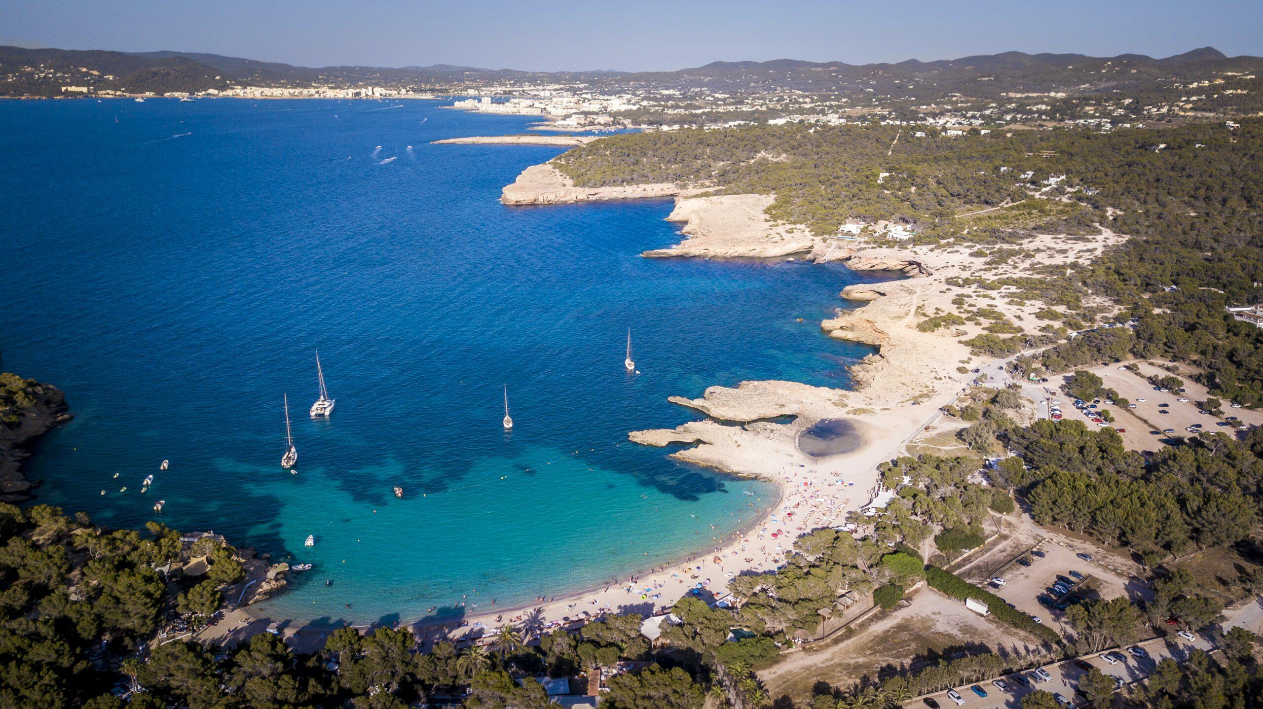 Vue aérienne de Cala Bassa à Sant Josep de sa Talaia, Ibiza, avec des voiliers et une plage de sable