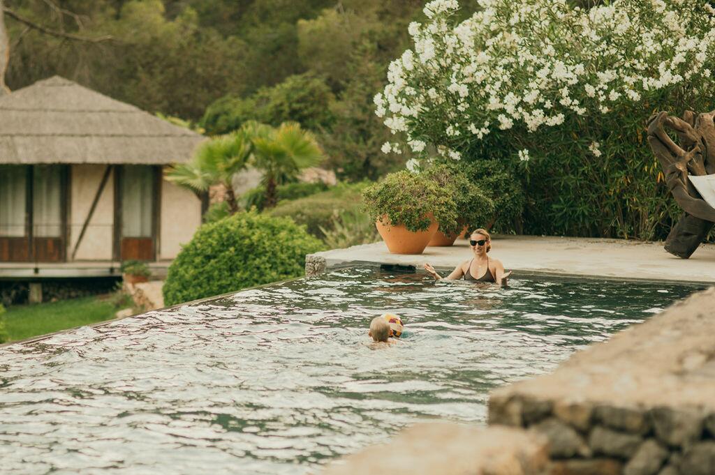 Piscine et jardin méditerranéen à la Villa Paradiso à Ibiza, avec des clients profitant de l’eau.